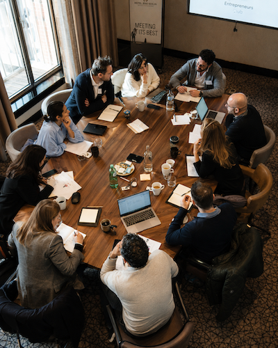 Unternehmerinnen und Unternehmer im Austausch an einem Tisch im Tagungshotel